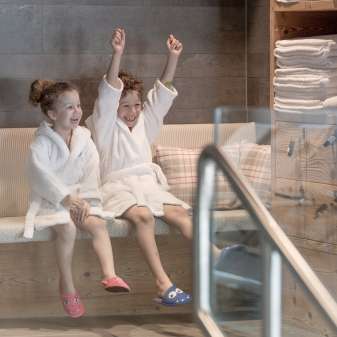 Twee kinderen in badjassen genieten van de wellnessruimte in Hotel Gorfion - gezinsvakanties met een feelgoodfactor in Malbun.