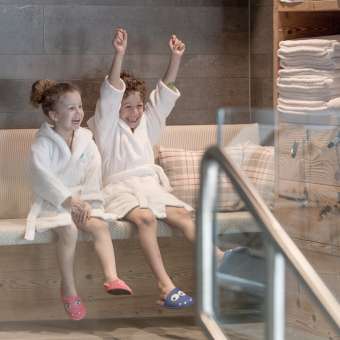 Twee kinderen in badjassen genieten van de wellnessruimte in Hotel Gorfion - gezinsvakanties met een feelgoodfactor in Malbun.