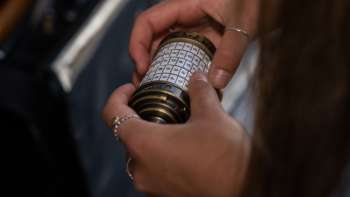 Twee vrouwen met iPads lossen puzzels op in de Outdoor Adventure Room in Malbun in een alpine omgeving