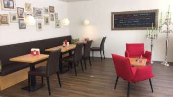  Gezellig café met moderne zitjes, decoratieve fotomuur en warme houten vloer