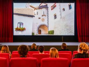 Bezoekers van de oude bioscoop in Vaduz bekijken een film met beelden uit Liechtenstein