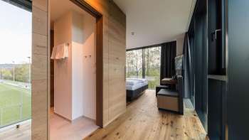Lichte kamer in Hotel Kommod met een elegante houten vloer en uitzicht op het groen