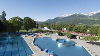 Algemeen zicht op het buitenzwembad van Mühleholz met verschillende baden en een prachtig Alpenpanorama op de achtergrond.