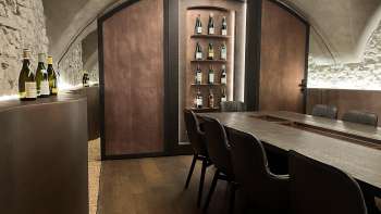 Elegant proeflokaal van de WY Weinbar met gewelfd plafond en elegante houten tafel voor exclusieve wijnproeverijen.