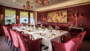 Gedekte tafel met mooi porselein, glazen en servetten bij daglicht