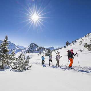 Sneeuwschoenwandelen door het besneeuwde landschap op de Schönberg bij Malbun onder een stralende winterzon.