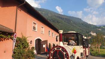 Citytrain  staat voor de historische Hofkellerei in Vaduz, klaar om te vertrekken.