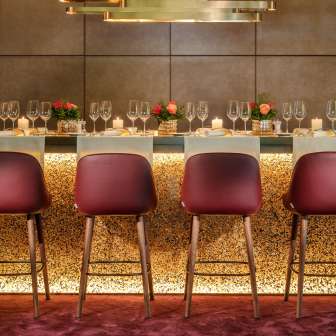 Elegant ingerichte bar met moderne stoelen, glazen en kaarslicht in het Park Hotel Sonnenhof in Vaduz, Liechtenstein