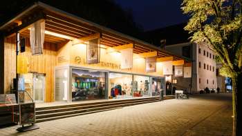 Modern bezoekerscentrum met glazen façade in Vaduz bij nacht, uitnodigend verlicht