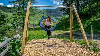 Een vrouw schommelt in de bergen van Liechtenstein en geniet van het uitzicht