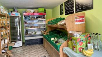  Verkoopruimte in de boerderijwinkel Aeulehof met verse groenten, drankjes en gekoelde rekken in Liechtenstein.