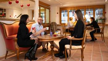Drie mensen in het Keramikcafé in Liechtenstein met koffie en thee in een gezellige loungesfeer.