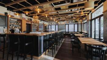 Licht interieur van de St. Martins Pub met bar, houten meubels en grote ramen