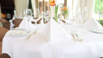 Feestelijk gedekte tafel met wit tafelkleed en verse tulp