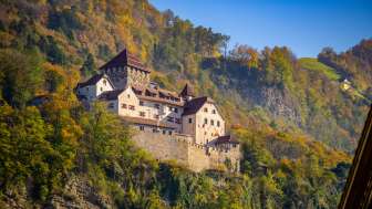 Kasteel Vaduz in Liechtenstein, omringd door herfstkleurige bomen en zonnige luchten
