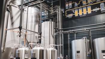 Technisch detail van een brouwproces met leidingen, tanks en diagram van de bierproductie.