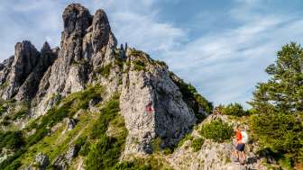 Twee wandelaars op het rotsachtige bergpad bij de Drie zussen in Liechtenstein langs Route 66 met een gemarkeerd klimgedeelte