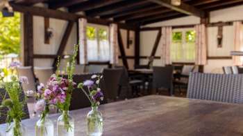 Gezellig terras met houten meubilair en mooie bloemdecoraties in potten