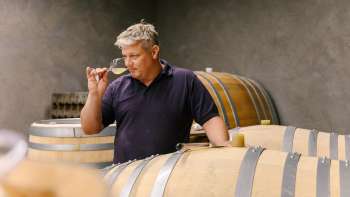 Wijnboer proeft wijn direct uit het vat in de wijnkelder