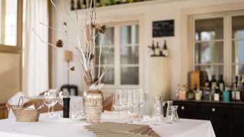 Decoratieve bar in het Vivid restaurant met stijlvolle glazen, flessen en natuurlijke sfeerverlichting