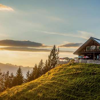 Gadafura hut op een zonnige bergweide met uitzicht op de bergen en zonsondergang