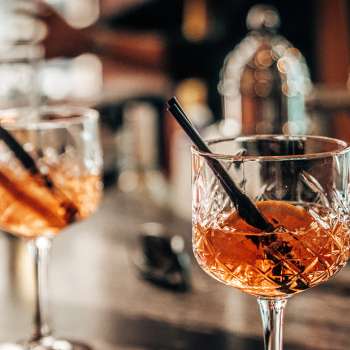 Twee aperitiefglazen met sinaasappelschijfjes op de bar