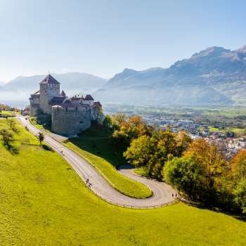 Kasteel Vaduz op een heuvel met uitzicht op de Rijnvallei en de omliggende bergen.