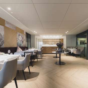 Ruime eetruimte met een elegante sfeer, grote tafels en moderne stoelen