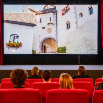 Bezoekers van de oude bioscoop in Vaduz bekijken een film met beelden uit Liechtenstein