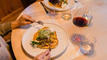 Close-up van een stijlvol bereid hoofdgerecht met rode wijn bij Gasthof Au.