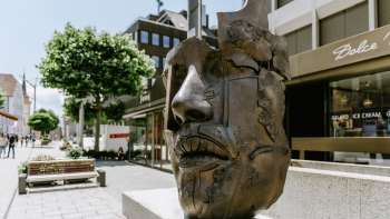 Bronzen sculptuur "African King" van Gunther Stilling met een abstract mannenhoofd in de voetgangerszone van Vaduz.