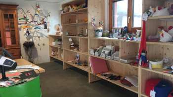Interieur van de Birkahoflädile met houten schappen vol regionale producten, decoratief ontworpen met kleurrijke elementen - boerderijwinkel in Liechtenstein.