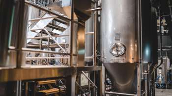 Grote roestvrijstalen tank en brouwtechnologie in de productieruimte van de Liechtensteinse brouwerij