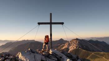 Wandelaarster bij het kruis op de top van Augstenberg