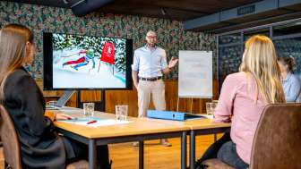 Moderne vergaderzaal met deelnemers aan een zakelijke bijeenkomst, presentatie over skiën in Liechtenstein op het scherm