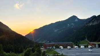 Op de camperplaats in Malbun staan verschillende campers, met op de achtergrond een bergpanorama