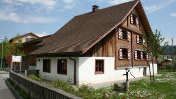 Historisch Küefer-Martis-Huus met traditionele houten gevel en rode luiken in Ruggell, Liechtenstein.