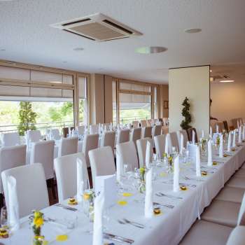 Feestelijk ingerichte kamer met een elegante tafelschikking, witte deksels en fijne details