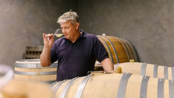 Wijnboer proeft wijn direct uit het vat in de wijnkelder