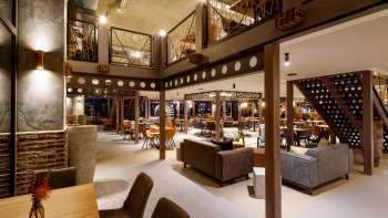 Elegante loungeruimte met modern design, stijlvolle zithoeken en open galerie in het ESSwerk