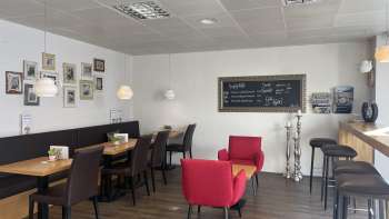  Gezellig café met moderne zitjes, decoratieve fotomuur en warme houten vloer