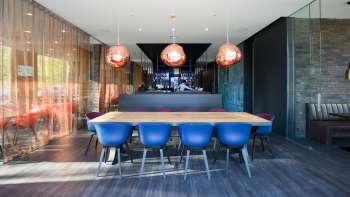 Modern restaurant met stijlvol interieur, blauwe designstoelen en elegante bar in het b_smart hotel