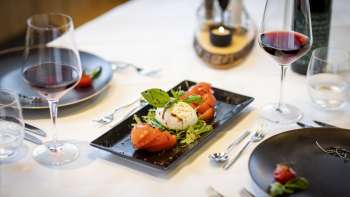 Nog een blik op de gedekte tafel, met de nadruk op de moderne zwarte borden en het servies in het midden.