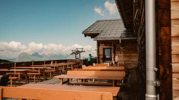 Lege houten banken op het panoramaterras van de Sareishut met uitzicht op de Alpen - ideaal voor een pauze tijdens een wandeling of ritje met de bergtrein.