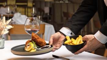 Geserveerd met gepaneerd vlees en frietjes in een moderne presentatie in het Alpspitz restaurant.