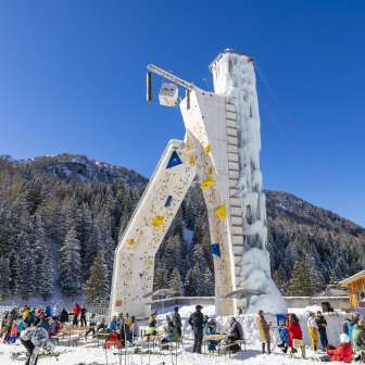 De ijzige klimtoren in Malbun omringd door wintergasten tegen een alpine achtergrond - een hoogtepunt voor wintersporters in Liechtenstein.