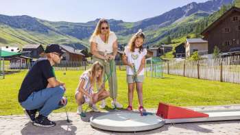Familie speelt minigolf op de Alpen-Minigolf in Malbun