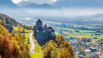 Kasteel van Vaduz met uitzicht op de Rijnvallei en het berglandschap.