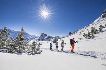 Sneeuwschoenwandelen door het besneeuwde landschap op de Schönberg bij Malbun onder een stralende winterzon.