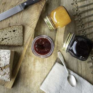 Verse boerenjam met boerenbrood en jampotten op een houten plank - geniet van een traditioneel ontbijt in Liechtenstein